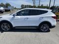 A side view of a white 2018 Hyundai Santa Fe with a sleek design and alloy wheels