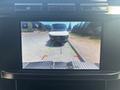 A rearview camera display showing a 2023 Ford F-350 SD approaching a white van with guidelines for parking assistance