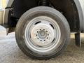 A close-up view of a 2010 Ford F-550 wheel showcasing a silver rim with multiple bolts and a black tire with tread pattern