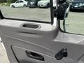 The interior door panel of a 2008 International DuraStar featuring a cup holder a door handle and a manual window crank
