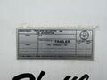 A metallic label affixed to a white surface displaying vehicle specifications including manufacturer details and tire dimensions