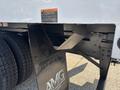 A close-up view of the rear section of a 2019 Freightliner M2 106 featuring a black mud flap with the logo of a motor group and visible supporting structure and dual rear tires