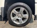 A close-up of a shiny chrome alloy wheel from a 2017 Chevrolet Silverado 1500 showcasing five spokes and a large tire with visible tread patterns