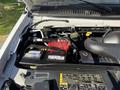 Engine compartment of a 2012 Ford Econoline E-450 showing the battery and various engine components including hoses and caps