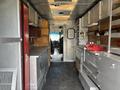 Interior view of a 2011 Workhorse W62 with metal shelves counters and equipment storage along the sides