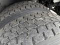 Close-up of a pair of worn tires with a deep tread pattern mounted on a 2021 Freightliner M2 106 vehicle