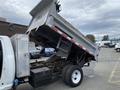 A 2011 Dodge Ram 5500 dump truck with its bed elevated showcasing the loading compartment and hydraulic lift system