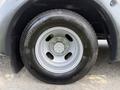 A close-up of a silver wheel on a 2020 Chevrolet Express featuring a Bridgestone tire with a distinctive tread pattern and five wheel lugs
