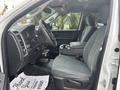 Interior of a 2016 RAM 1500 showing the driver's side with leather seats and a center console featuring cup holders and storage compartments