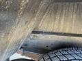 Close-up of a 2012 Ford Econoline showing a section of the undercarriage with rust and a tire in view