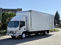 A white 2019 Isuzu NRR box truck is parked on a street with a large cargo area and a cab featuring a rounded hood and front grille