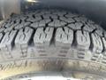 A close-up of a rugged tire with deep treads mounted on a 2012 RAM 2500 showcasing its durability and traction