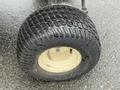 A close-up of a black tire with a rugged tread pattern mounted on a metallic rim displaying the Carlisle brand name and size details