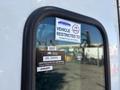 A close-up of a window on a 2015 Peterbilt 337 displaying vehicle restriction decals and a certificate of approval sticker