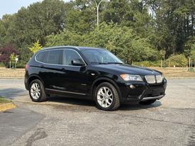 A black 2013 BMW X3 parked with a sleek design featuring prominent kidney grilles and alloy wheels