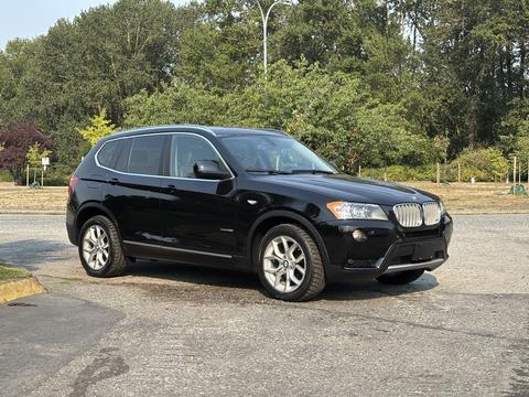 A black 2013 BMW X3 parked with a sleek design featuring prominent kidney grilles and alloy wheels