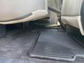 The floor of a 2016 Ford F-150 with a rubber mat and carpet showing underneath the front seats