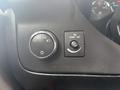 Close-up of the dashboard controls of a 2020 Chevrolet Express featuring a knob for headlights and a button for dome light control
