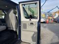 A 2013 Ford E-350 Super Duty van with an open side door revealing the interior seat and panel details