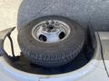 A 2020 Chevrolet Express van with a spare tire mounted on the roof, featuring a steel wheel and a Michelin tire with visible tread patterns