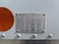 A metallic identification plate mounted on a vehicle featuring the text Hino 338 and manufacturer details