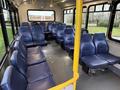Interior of a 2020 Chevrolet Express van featuring multiple rows of blue vinyl seats with yellow railings and a spacious layout designed for passenger transport