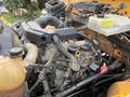 Close-up view of the engine compartment of a 2013 International 4300 showing various components such as hoses, caps, and the engine block