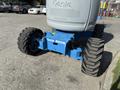 A blue Genie Z 45/25 aerial lift with large rubber tires and a sturdy base designed for elevating workers to high places