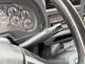 Close-up of a 2007 GMC F7500 steering column with a control stalk for turn signals and hazard lights alongside the instrument panel showing speed and fuel gauges