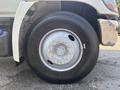 A close-up of a 2012 Hino 338 truck wheel showcasing the silver rim and black tire with visible tread pattern and lug nut details