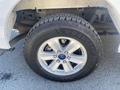 A close-up view of a silver alloy wheel from a 2017 Ford F-150 featuring a Goodyear Wrangler tire with visible tread pattern
