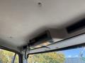 Interior view of a 2012 Freightliner M2 106 featuring the overhead console with lights and a mounted microphone