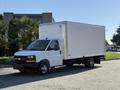 A white 2024 Chevrolet Express box truck with a large cargo area and a single cab, parked on a street