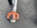 Three Honda Lawnboy mowers and two Stihl line trimmers stacked together with distinct orange and black colors on the trimmers