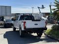 A 2017 Ford F-350 SD in white with a black bed rack parked in a lot