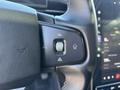 Close-up of the steering wheel in a 2023 Fisker Ocean showing control buttons for various vehicle settings and functions