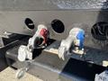 Close-up of two valves on a black chassis of a 2013 International 7500 one red and one blue with a silver handle and a metal ring attached
