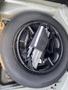 A compact spare tire with tools and equipment is neatly arranged inside the trunk of a 2013 Mercedes-Benz C-Class