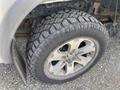 A close-up of a rugged tire on a 2014 Ford F-150 showcasing its deep tread design and alloy wheel visible through the tire rim