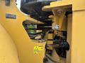 Close-up of a 2012 Caterpillar 980's hydraulic components and articulation system showing yellow metal parts and warning labels