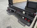 A 2008 Ford F-550 with a black bed and visible brake lights tailgate and rear steps