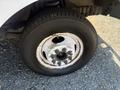 Close-up of a tire and wheel from a 2012 Ford Econoline showing wear and rust on the rim with a standard tread design