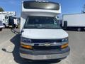 A white 2020 Chevrolet Express van with a large raised roof and a prominent front grille featuring the Chevrolet logo