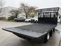 A 2015 Hino 195 flatbed truck with a black mesh grille and wooden loading surface facing away from the camera