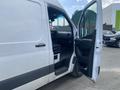 A 2024 Mercedes-Benz Sprinter van with the driver's side door open showcasing the interior and front seating area