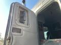 A close-up view of the driver's side door of a 2009 Peterbilt Highway truck revealing the door handle and interior controls