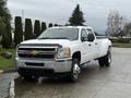 A white 2013 Chevrolet Silverado 3500HD pickup truck with a chrome grille and large tires parked with the cab facing forward