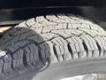 Close-up of a rugged tire tread on a 2012 RAM 2500 showcasing deep grooves and textured rubber for enhanced traction and off-road capability