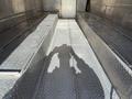 Interior view of a 2017 Freightliner MT45 with metal flooring and a shadow cast by a person holding a dog