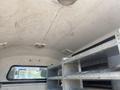 Interior view of a 2014 Ford F-350 SD showing a ceiling with light fixtures and metal shelving on the sides